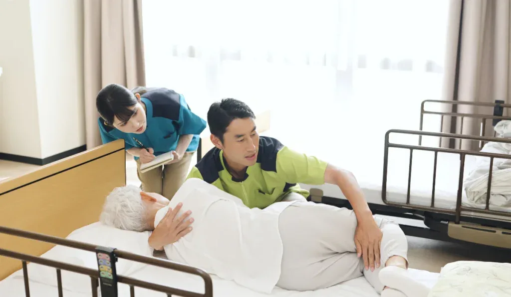 Asian caregiver instructing how to change positions