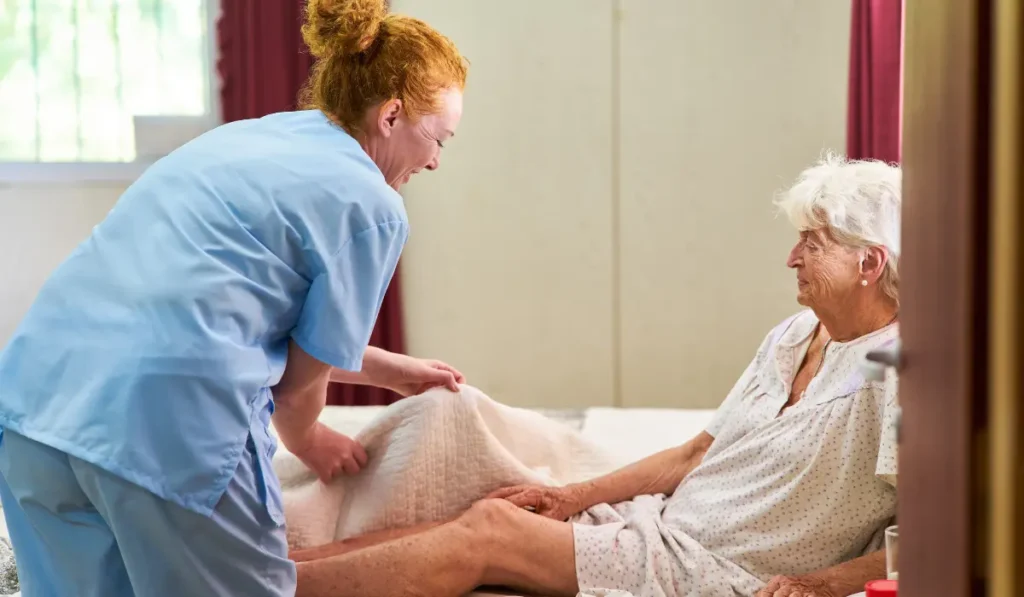 caregiver preparing older women to take a bed bath