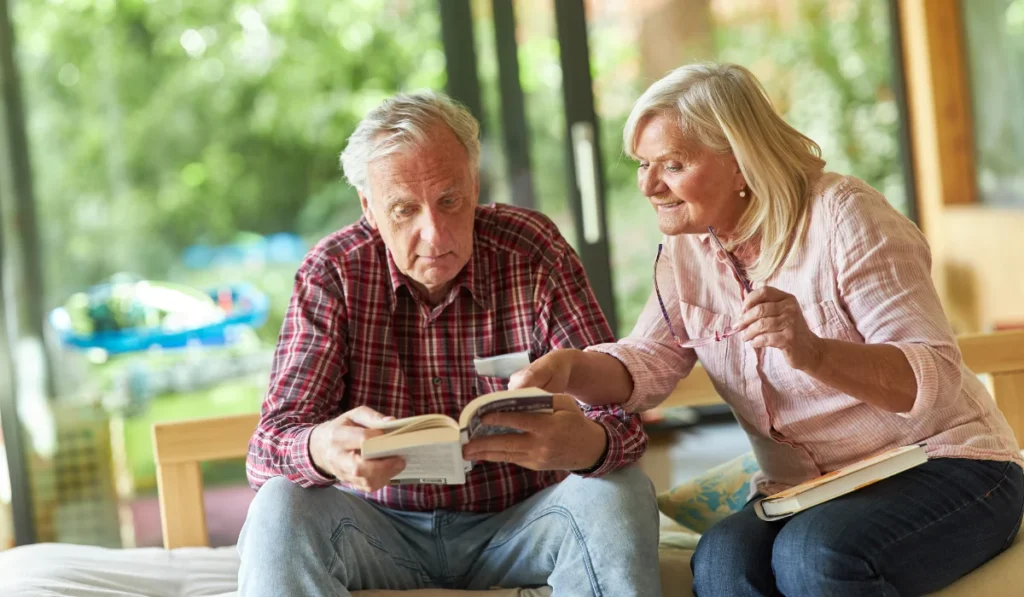 Senior Couple in the Living Room Reading a Book